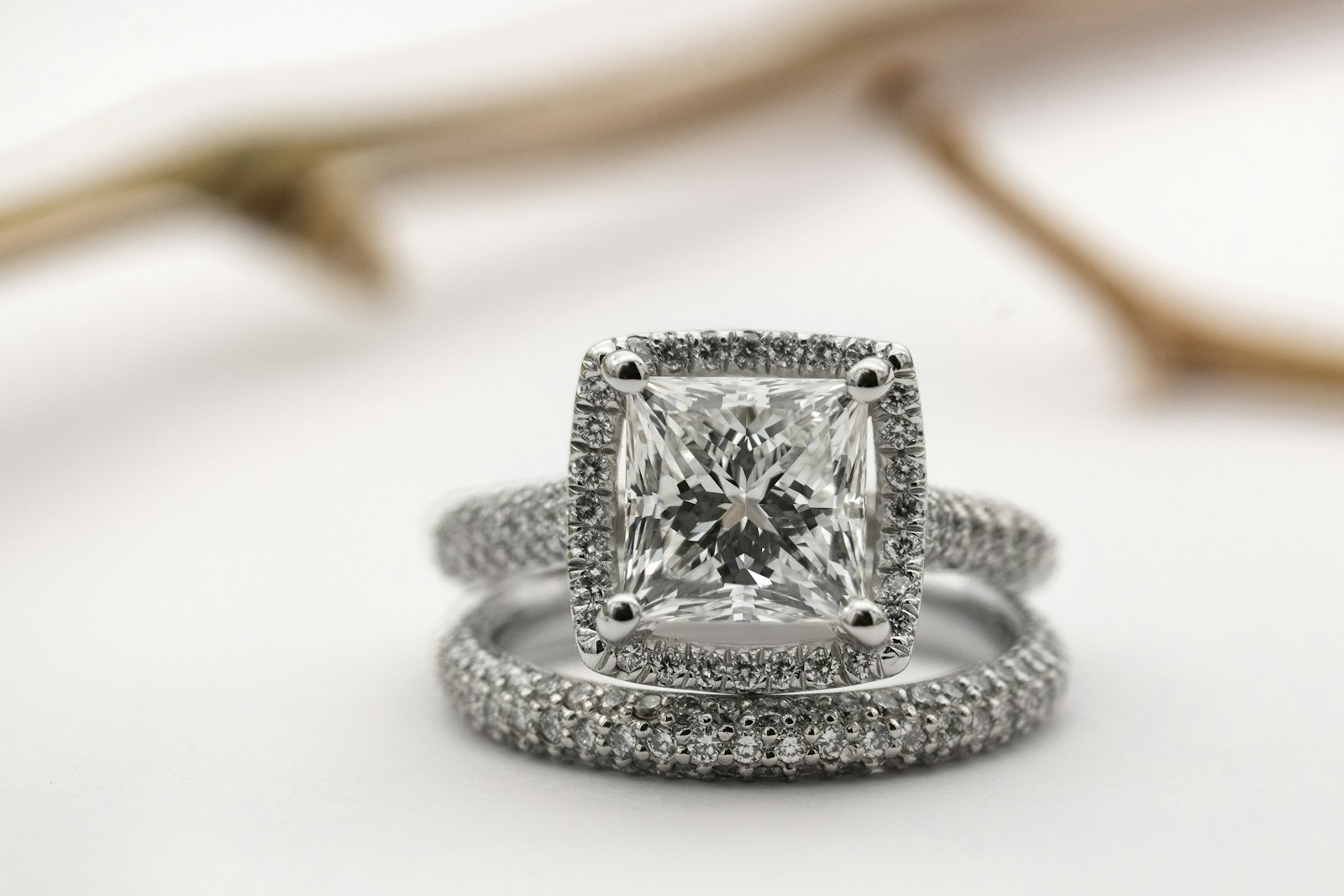 A princess-cut diamond halo ring with a pavé band